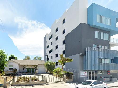 Architect's drawing of a large building next to a single family home.